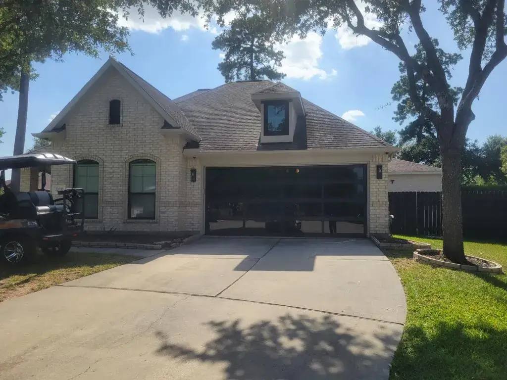 Dark glass-panel garage door on a brick home