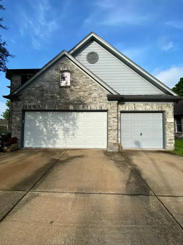 White garage doors on a brick home