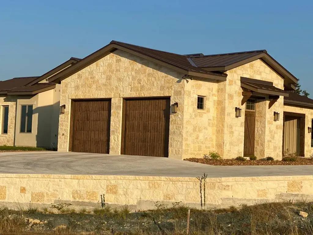 Wood-look garage doors on a stone home